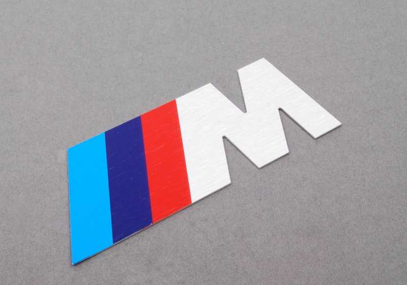 Emblema letra "M" frontal OEM 72601312802 para BMW E34 M5 (HD91, HD92, HC91, HC92, HJ91). Original BMW.