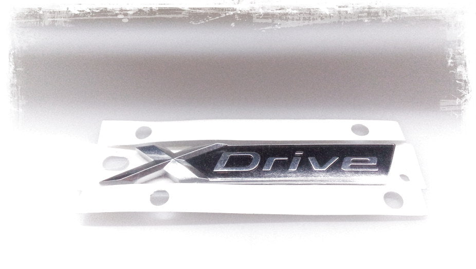 Emblema X-Drive OEM 51147437102 para BMW G31 (520d xDrive, 530d xDrive). Original BMW.