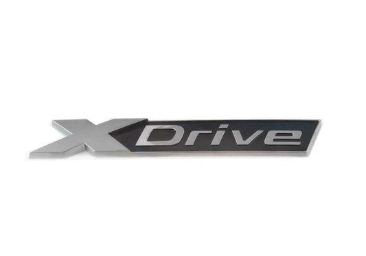 Emblem "X Drive" OEM cinza escuro 51148072625 para BMW G12 e G12N. BMW original. Ideal para substituição ou personalização, mantendo o design original do veículo.