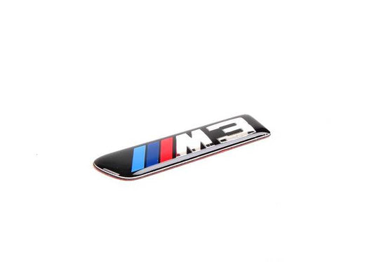 Emblema adhesivo lateral izquierdo OEM 51138042227 para BMW E90, E90N, E92, E92N, E93, E93N. Original BMW.