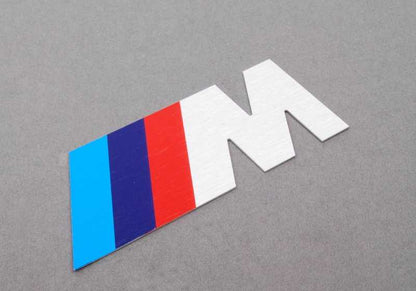 Emblema letra "M" frontal OEM 72601312802 para BMW E34 M5 (HD91, HD92, HC91, HC92, HJ91). Original BMW.