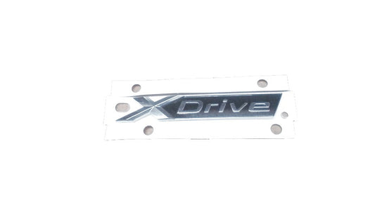 Emblema X-Drive OEM 51147437102 para BMW G31 (520d xDrive, 530d xDrive). Original BMW.