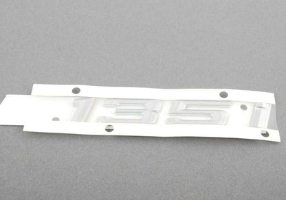 Emblema trasero adhesivo OEM 51147183159 para BMW E82, E88. Original BMW.