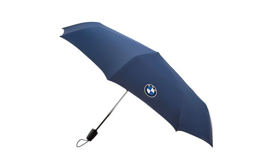 Folding umbrella BMW OEM 80235B5F620. Automatic, compact and light opening. Original BMW. Ideal for any BMW model as a Lifestyle accessory. Elegant design with central logo.