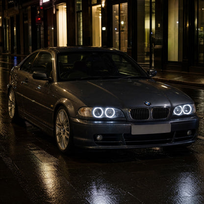 BMW Série 3 E46 coupé cinzento-escuro, à noite, numa rua molhada, com angel eyes LED brancos, dois anéis por farol
