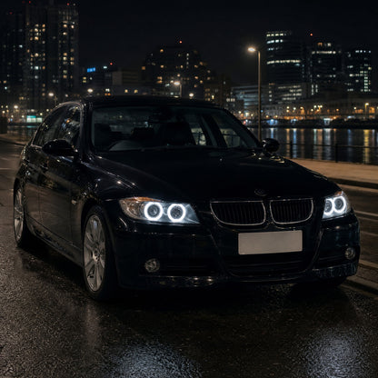 BMW Série 3 E90 berlina preto, à noite, com anéis LED brancos de angel eyes nos faróis de halogéneo