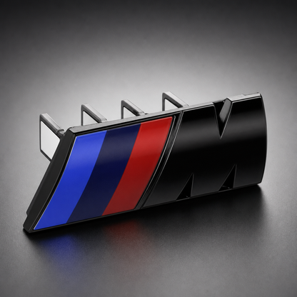 Emblema M para parrilla BMW Negro brillante con franjas tricolor y clip trasero en packshot premium